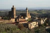 Photographie aérienne d’un hameau médiéval à flanc de colline, en Toscane (Italie)