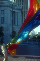 A person arranging a colorful flag hanging from a pole