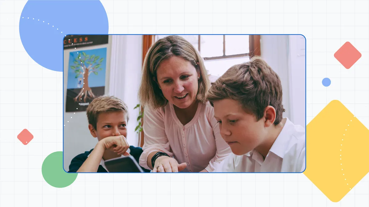 A female teacher in the classroom speaking with 2 male students who are looking at a tablet.