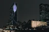 Image of the UN building at night with a colorful projection on its side.