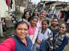 A group of women dressed in traditional Indian outfits smiling at the camera