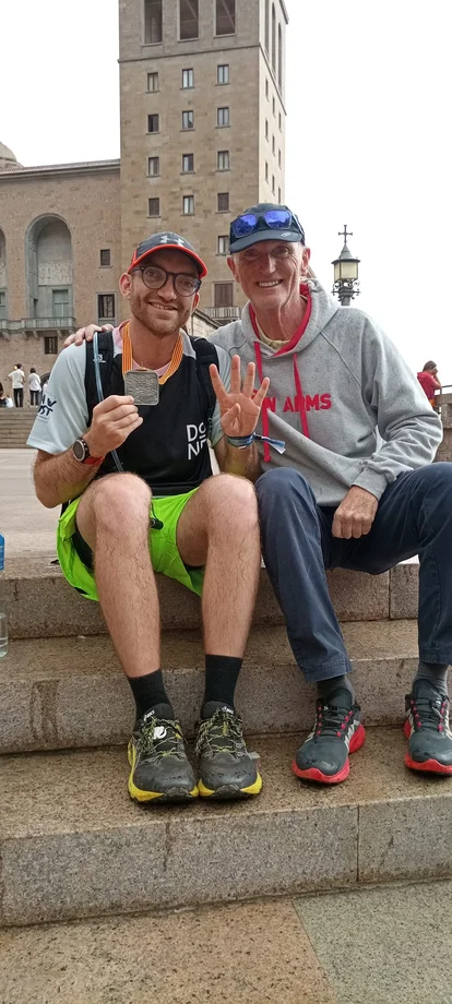 Ein Gruppenfoto von Jan und seinem Vater in Barcelona, sitzend auf Treppenstufen.