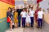 A picture of Googlers in the Google Accra offices in front of a Ghana flag with Google embossed on it.