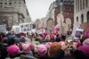 Photograph of the women’s march in Washington, DC in 2017. Crowd shown of people wearing pink hats and holding signs reading “Women count,” “Resist” and “Yes we can.”