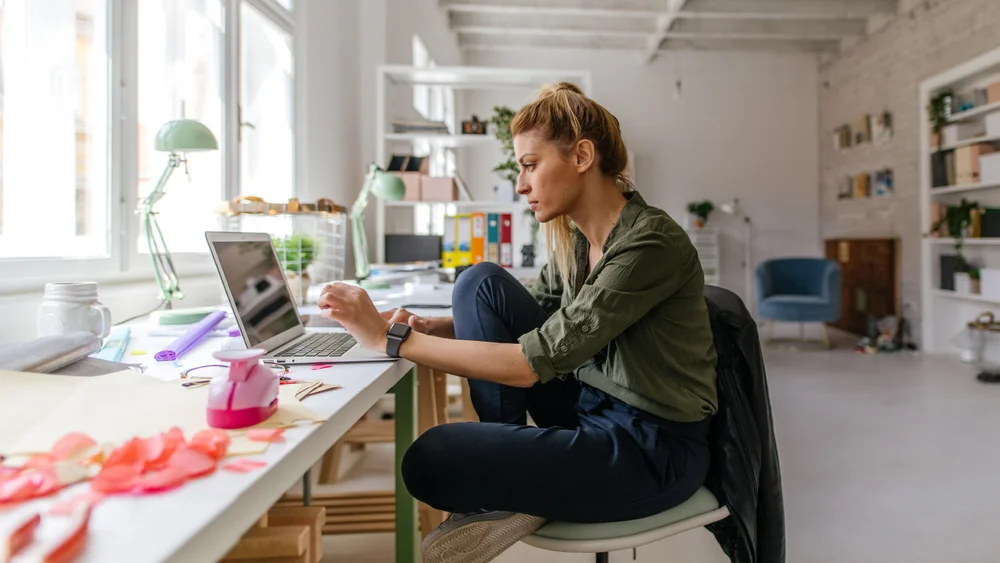 Woman using laptop: WooCommerce to integrate with Google shopping features across Search, Shopping, Image Search and YouTube