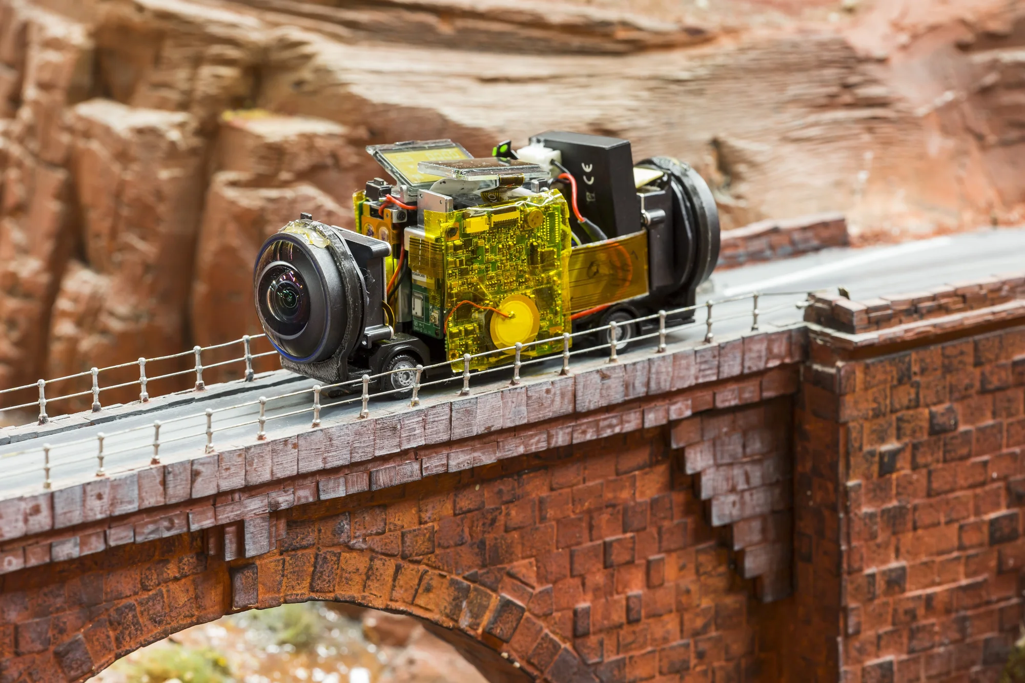 Foto eines Modell-Busses auf dem winzige Kameras montiert wurden, der auf Straßen des Miniatur Wunderlands unterwegs ist.