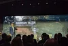 a man speaks to a crowded room at the UN SDG Pavilion