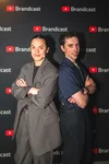 Ashley Chang and Mike standing back to back in front of a Brandcast photo wall