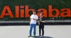 James Park and Zhenfei Liu standing in front of a red Alibaba sign