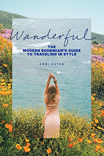 Andi wears a pink dress and raises her arms in a field of wildflowers overlooking the ocean, on the cover of her Bohemian travel guidebook.