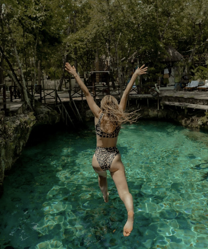 Andi wears a two-piece leopard-print swimsuit as she leaps into a green pool of water