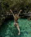 Andi wears a two-piece leopard-print swimsuit as she leaps into a green pool of water