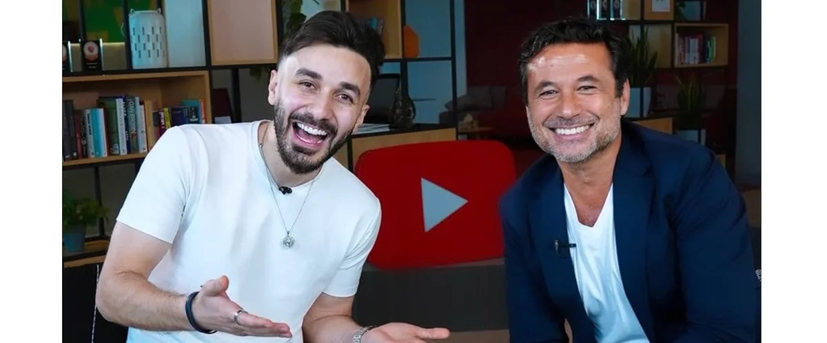 Image showing two people sitting and smiling with YouTube logo behind them