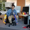 Robert at his desk holding two nerf guns.