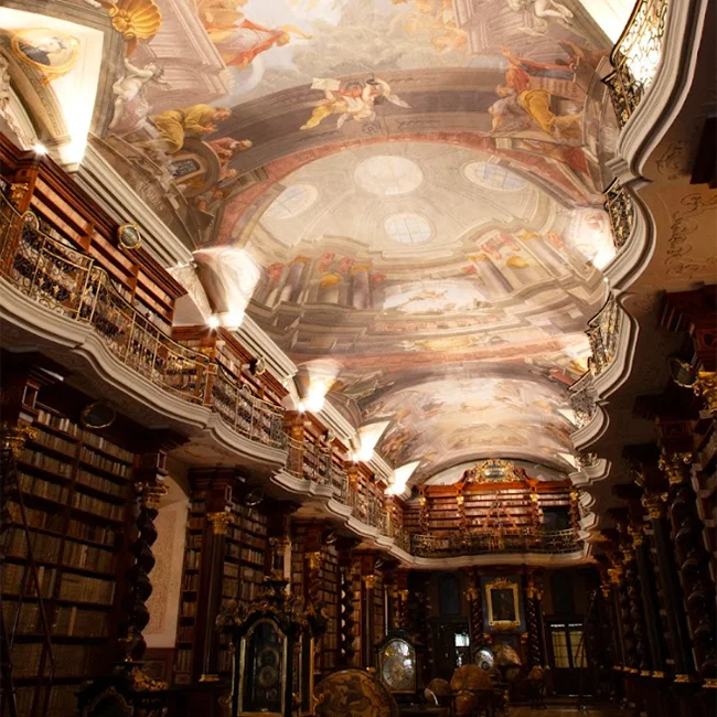 An opulent Baroque Library with ornate ceiling frescoes towering over rows of wooden bookshelves, radiating the grandeur of a bygone era.