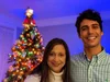 Image showing the author with his mother in front on a decorate tree in a dark room. The subjects are well-lit and in focus while the background is blurred.