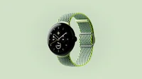 The Google Pixel Watch with a soft green band against a green background