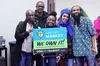 A group of people holding a sign advertising Gem City Market in Ohio