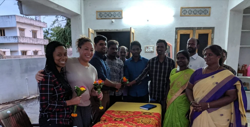 From left to right, Diana and Courtney are pictured holding flower bouquets gifted to them by the farmers they're pictured with, as they visited the farmers they work with in Vijayawada, India to observe an information exchange.