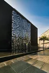 Calligraphy sculpture of quranic verse made of stainless steel in front of a pool of water in public