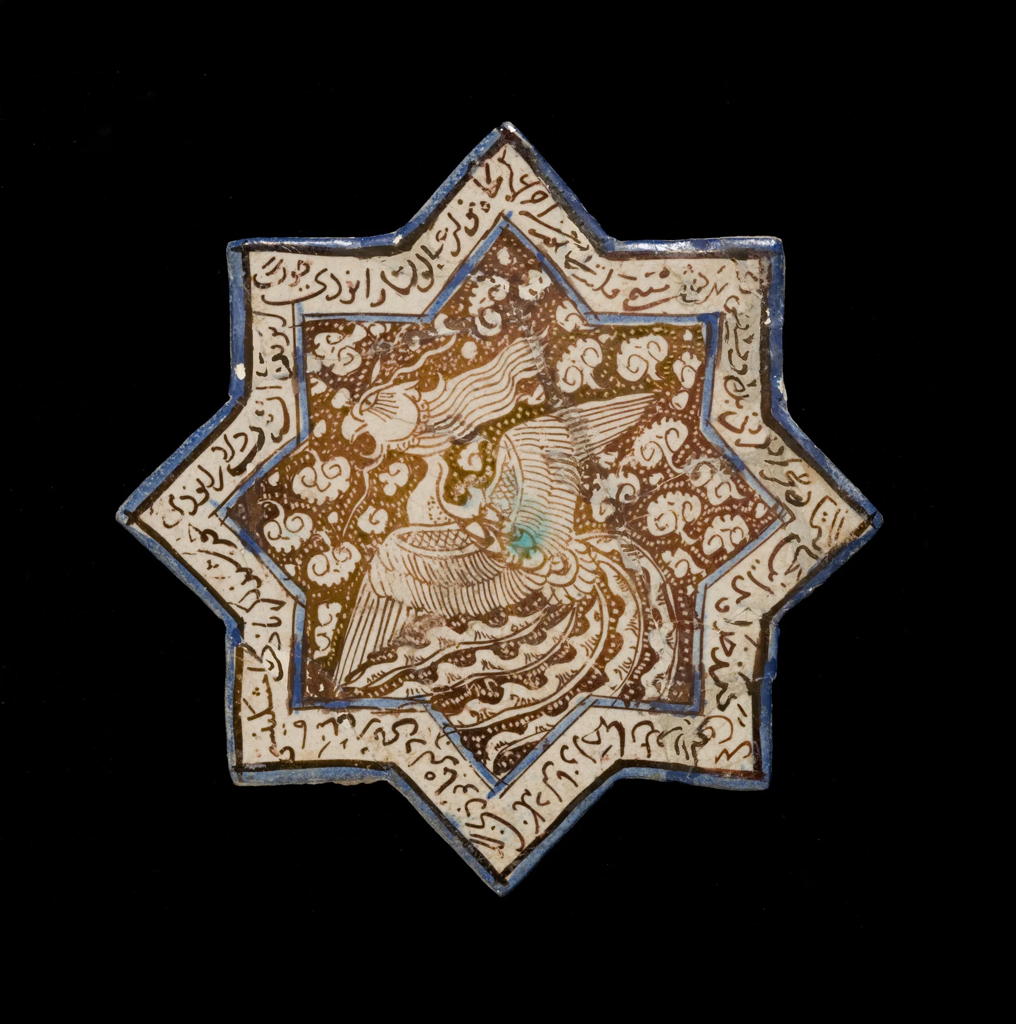 A white and brown star shaped tile with an image of a phoenix spreading its elaborate plumage in the center, surrounded by Chinese-style clouds.