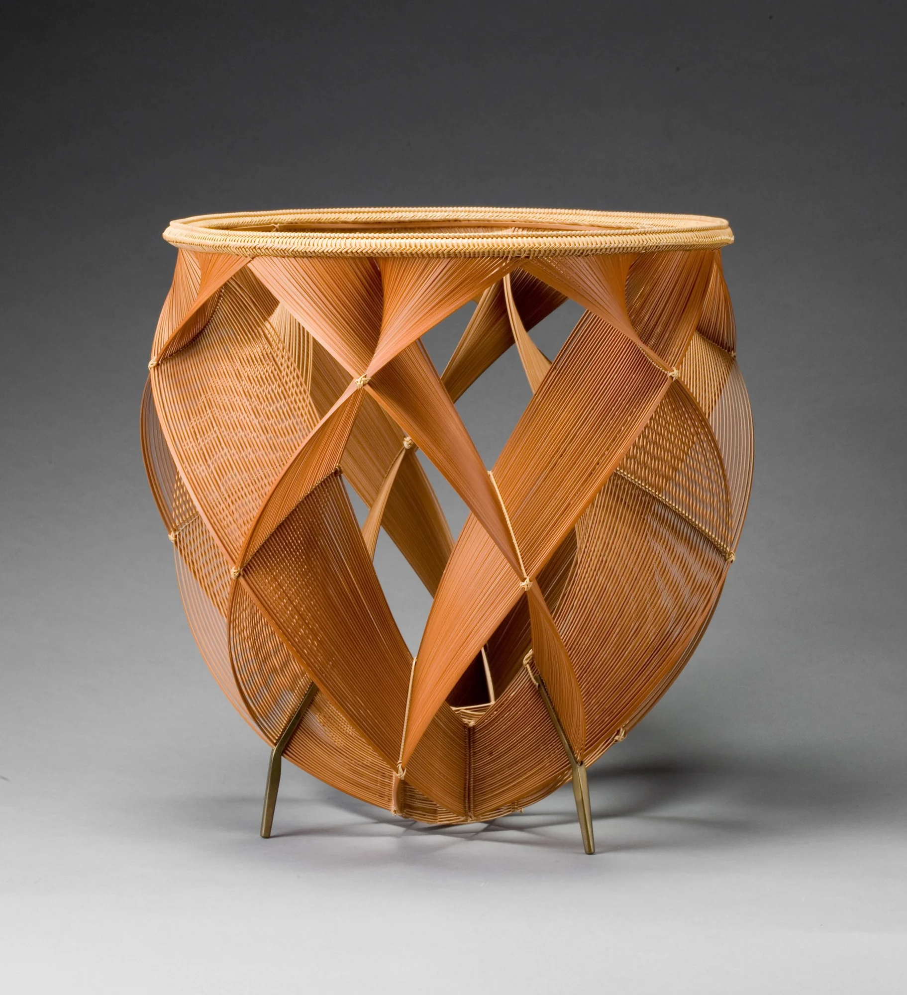 A dark brown bamboo basket using an open construction of interwoven ovals, with a light brown rim at the top.