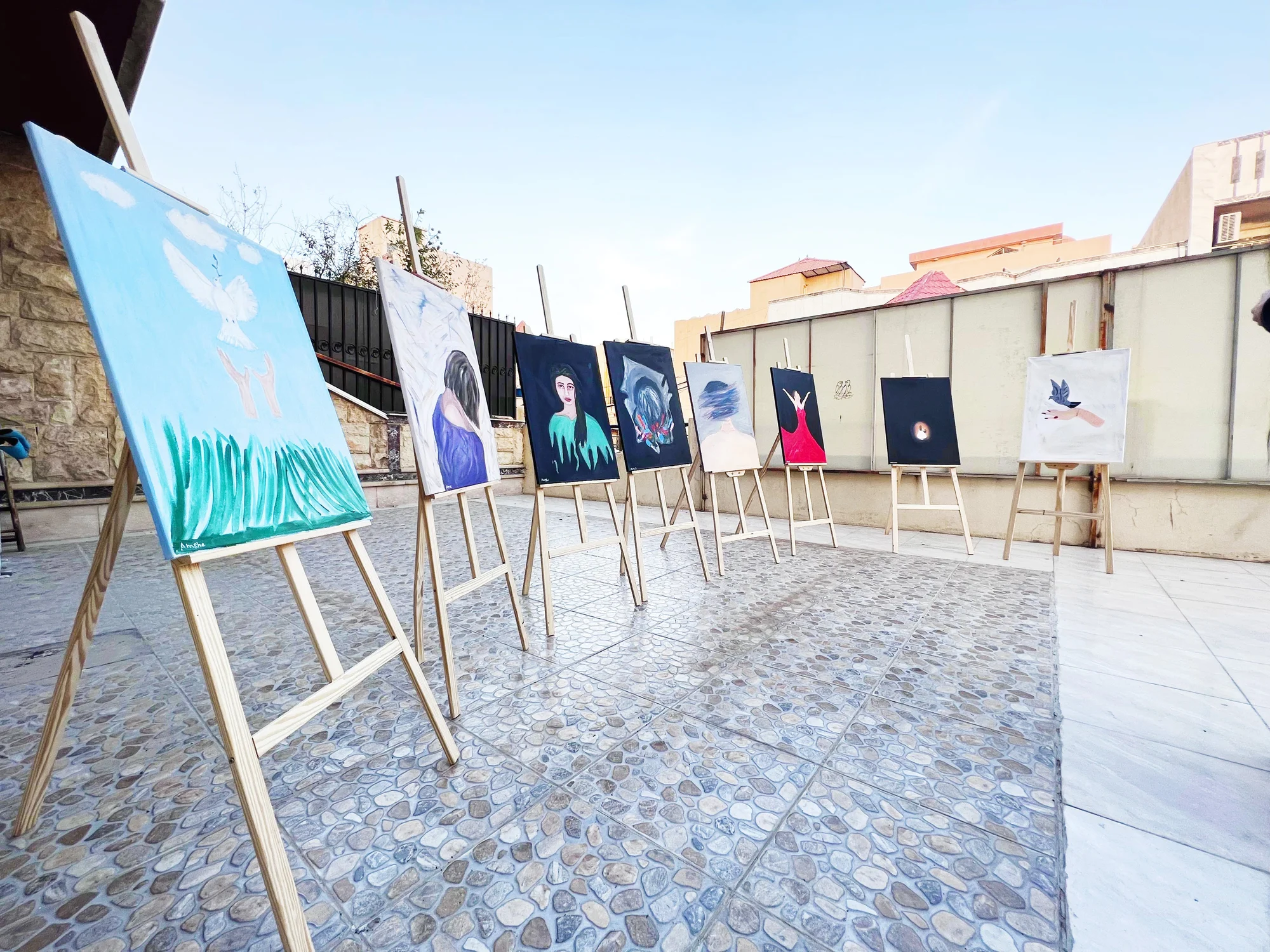 Photo of different paintings in a courtyard as part of an artist-led workshop.