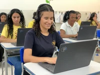 Mulher sendo treinada por programa do Amigos do Bem pelo computador.