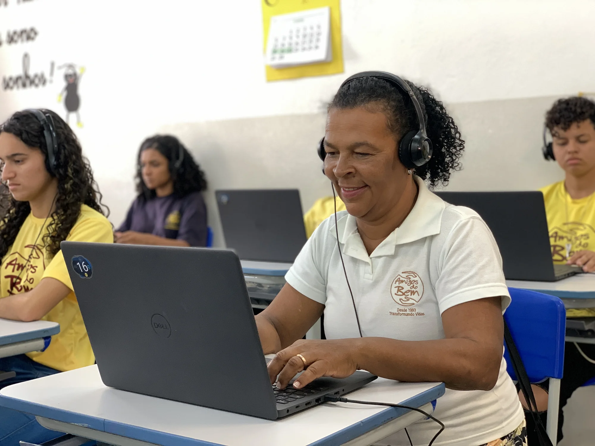 Mulher sendo treinada por programa do Amigos do Bem pelo computador.