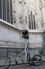 A trike with cameras attached parked in front of a cathedral