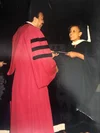 Melonie Parker in a graduation cap and gown receiving her diploma from Hampton University.