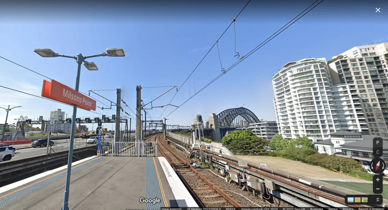 Street View imagery of the platform at Milsons Point train station in Sydney, with a spectacular view of the Harbour Bridge.