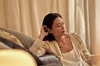 A woman sits on the couch listening via Pixel Buds Pro.