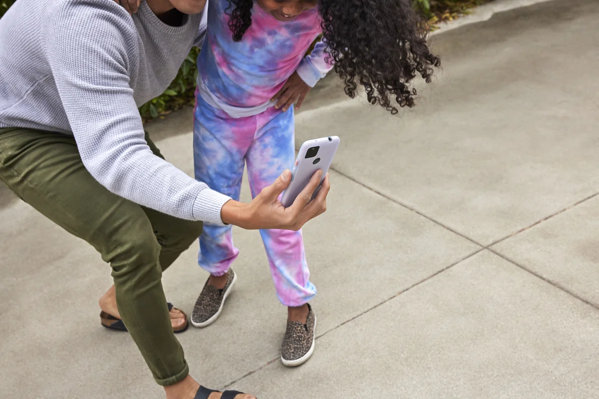 An owner of a Pixel 5a with 5G and the Partially Pink case, takes a selfie with a child.