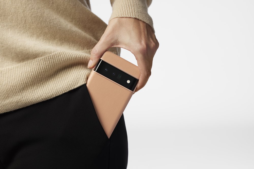 A person pulling a tan leather case on a Pixel 6 out from the pocket of black pants