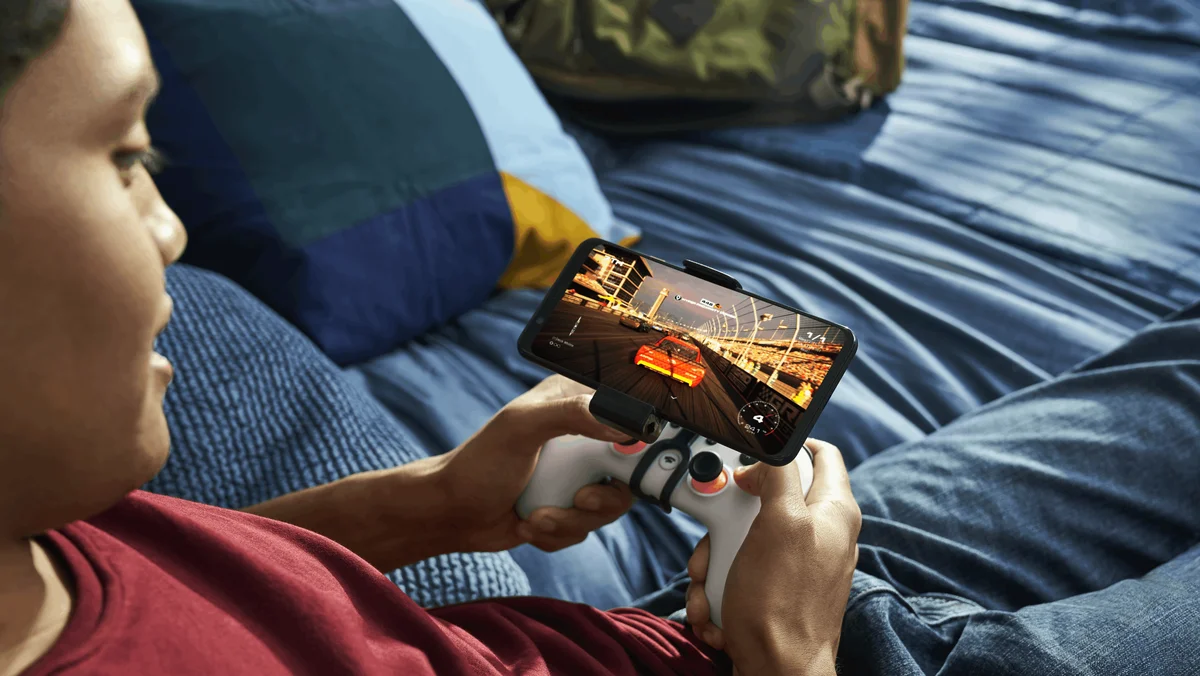 A teenage plays Stadia on his phone.