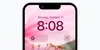 An iPhone Lock Screen with a photo of pink flowers and two Search Lock Screen widgets. One shows the Google Search bar, the other shows the Lens Translate icon.