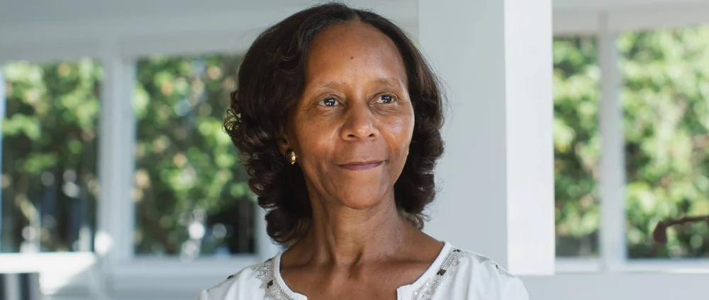 Marian Croak in her home, wearing a white shirt and looking to the side.