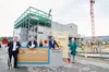 Auf dem Bild sieht man fünf Personen, die vor der Baustelle eines Rechenzentrums in Hanau stehen.