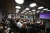 A photo of a group of business people sitting on chairs in a conference room all facing a stage for the summit