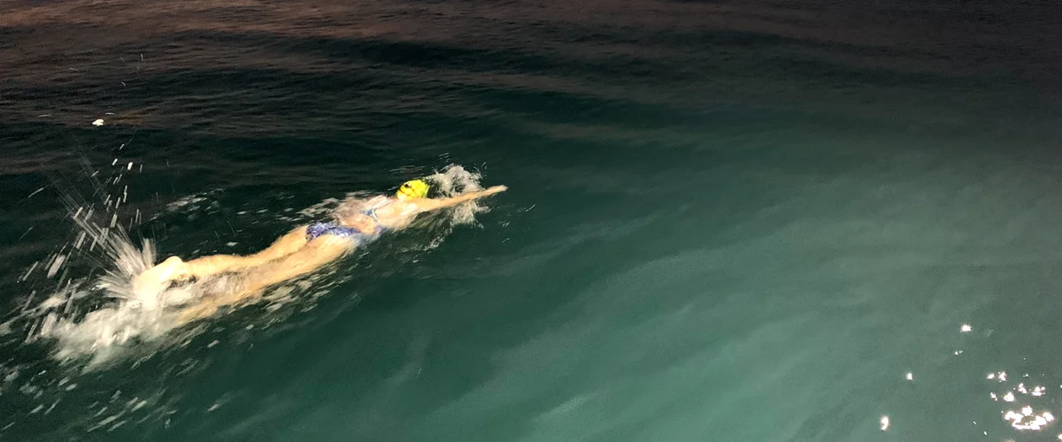 A woman in a bathing suit swimming in water.