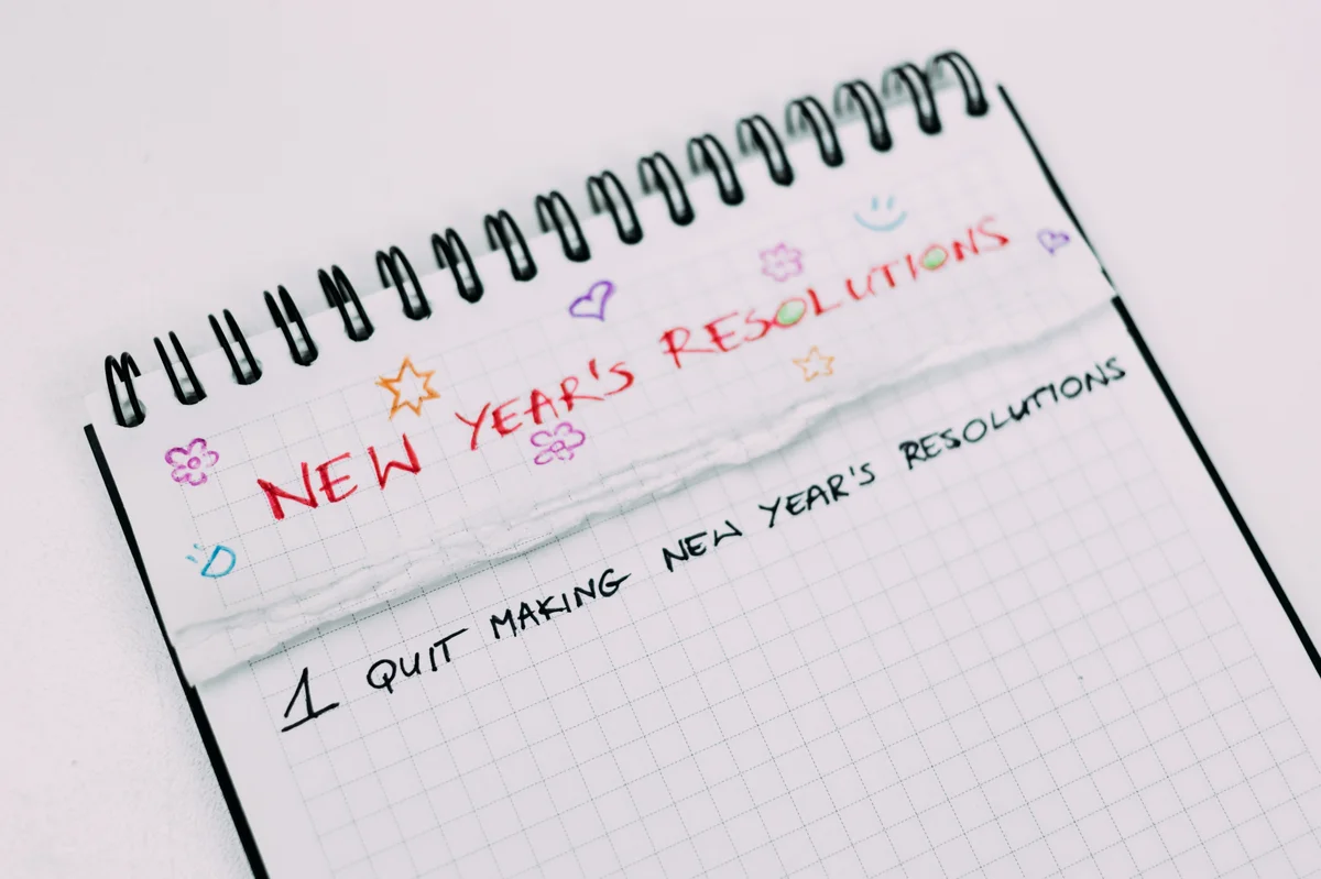 Image showing a notebook with "New Year's Resolutions" written at the top. Below is the number one and the words "quit making new year's resolutions."