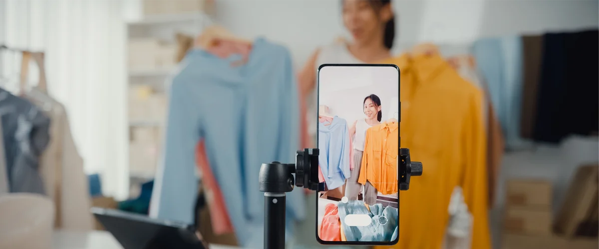 Store owner takes video of her shop with mobile phone.