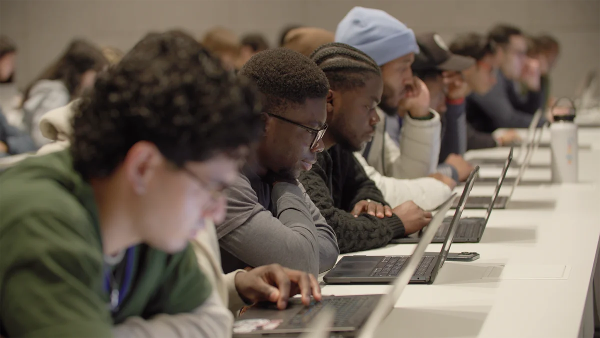 Rows of Tech Exchange students attending the program kick-off session use laptops to completing an assessment during their on-boarding