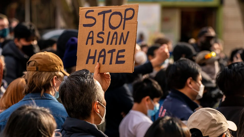 A "Stop Asian Hate" protest sign being held up in a crowd of demonstrators