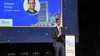 Google CEO Sundar Pichai standing on stage at a lectern giving a speech