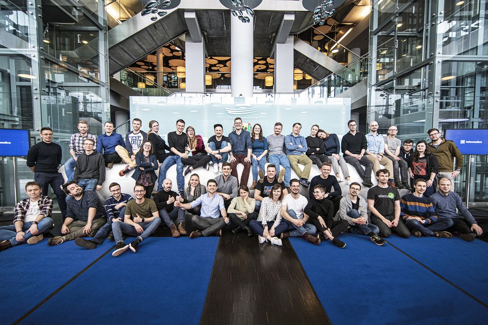 photo of several dozen employees in a big office lobby