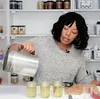 YouTube Creator Tiana Coats pours wax into jars to make candles