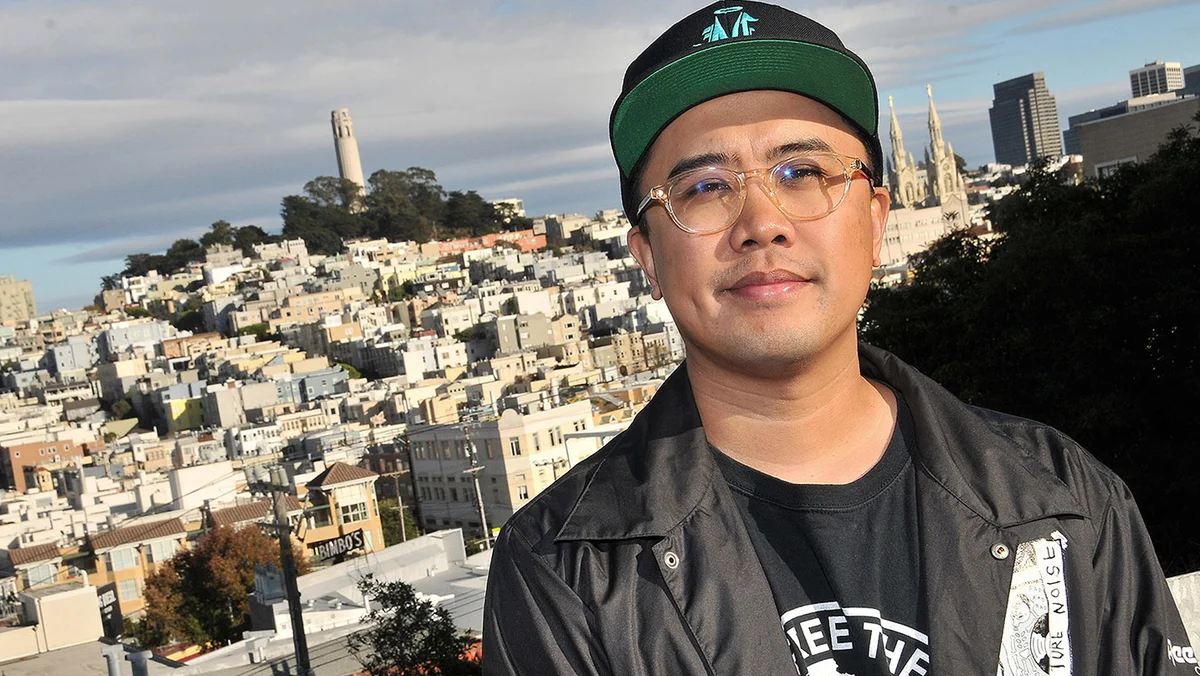 Photo of Richie looking into the camera; the city of San Francisco is in the background behind him.