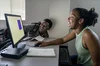 Two students looking at laptop together and laughing.